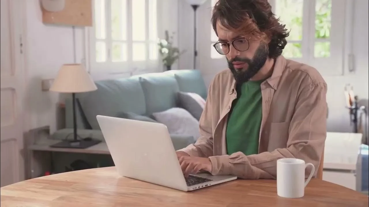 Person working remotely on a laptop with a coffee mug nearby.